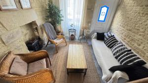 a living room with a couch and chairs and a fireplace at La Vigie - Maison en bord de mer in Lion-sur-Mer