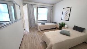 ein Schlafzimmer mit zwei Betten und einem Fenster in der Unterkunft Villa Ruths Stay Polle in Kouvola