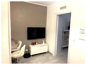 a living room with a television and a white cabinet at Teti Suite Rooms in Pozzallo