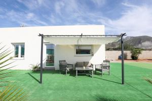 a patio with chairs and a canopy on a lawn at EyA House in Padul