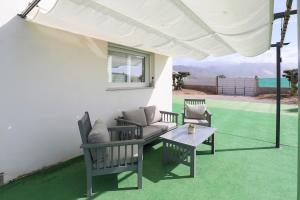 a patio with a couch and chairs and a table at EyA House in Padul