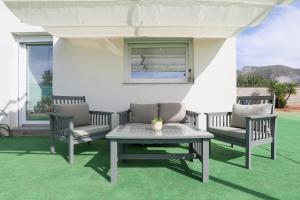 a patio with two chairs and a table and a window at EyA House in Padul