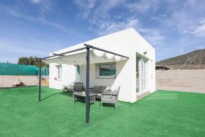 a white house with a patio with green grass at EyA House in Padul +23 photos
