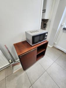 een magnetron bovenop een houten kast bij The Walnut in Aveley