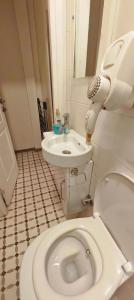 Un baño con un inodoro blanco y un lavabo. en Mimoza İstiklal Apart Hotel, en Estambul