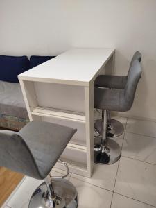 a white desk with two chairs and a table at Apartman Ivana in Slavonski Brod +1 photo