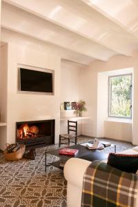 een woonkamer met een bank en een open haard bij Casa de diseño con gran terraza in Cantallops