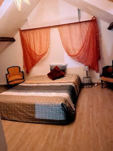 - une chambre avec un grand lit et des rideaux orange dans l'établissement Le petit calme, à Frameries 3 autres photos
