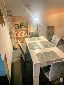 Cette chambre comprend une table avec des chaises et une lampe. dans l'établissement Le petit calme, à Frameries