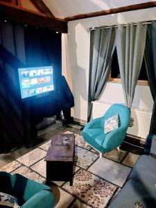 un salon avec une chaise bleue et une table dans l'établissement Le petit calme, à Frameries