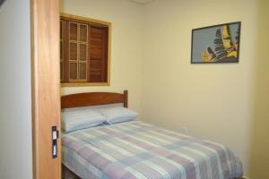 a small bedroom with a bed and a window at Seu lugar na Mantiqueira é aqui! Seja bem-vindo! in Itanhandu