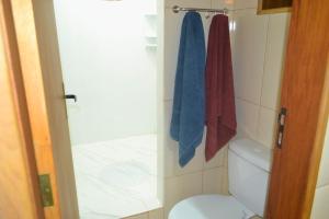 a bathroom with a toilet and a shower with blue towels at Seu lugar na Mantiqueira é aqui! Seja bem-vindo! in Itanhandu +24 photos