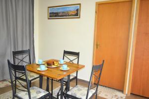 a wooden table with chairs and a wooden door at Seu lugar na Mantiqueira é aqui! Seja bem-vindo! in Itanhandu