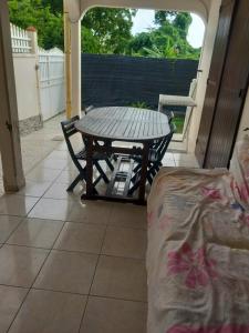 a table and a chair on a patio at lorispring in Îlet à Christophe