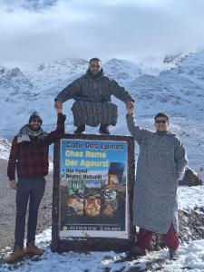 three men standing next to a sign with a sheep on it at Dar Agourzi Café des Epices in Tacheddirt