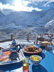 a table with a plate of food on top of a mountain at Dar Agourzi Café des Epices in Tacheddirt