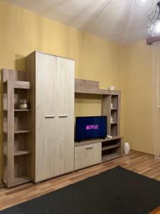 un grande armadio in legno con TV in camera di Boulevard Serenity Apartment a Miercurea-Ciuc