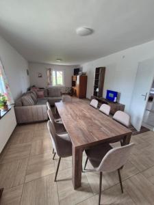 uma sala de estar com uma mesa e cadeiras de madeira em Apartmani Petrović SEMČE Suva Planina em Gadžin Han mais 38 fotografias