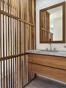 une salle de bain avec un lavabo et un miroir dans l'établissement Casa Moderna, Barrio Nayades, à Pinamar