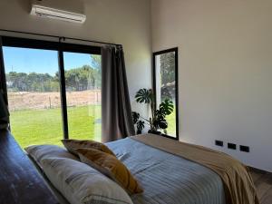 une chambre avec un lit et une grande fenêtre dans l'établissement Casa Moderna, Barrio Nayades, à Pinamar