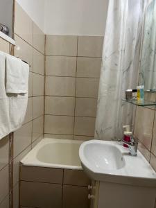 un bagno con lavandino e vasca da bagno di Boulevard Serenity Apartment a Miercurea-Ciuc