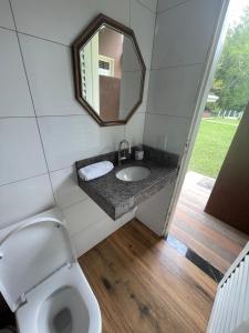 ein Badezimmer mit Toilette und Spiegel in der Unterkunft Sítio Chalako, casa exclusiva às margens do Rio Mimoso in Bonito
