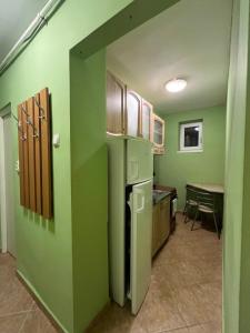 una piccola cucina con pareti verdi e tavolo di Boulevard Serenity Apartment a Miercurea-Ciuc Altre 7 foto