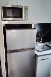 a microwave on top of a refrigerator in a kitchen at Studio Alizée accès direct Promenade Marcel Proust in Cabourg +6 photos