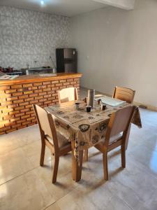 a dining room table with chairs and a kitchen at Casa por do sol Flecheiras in Flecheiras