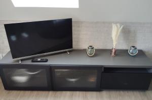 a black entertainment center with a flat screen tv on top at Studio Alizée accès direct Promenade Marcel Proust in Cabourg