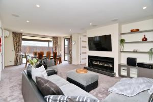 uma sala de estar com um sofá e uma lareira em Spacious Family & Group Retreat - Wigram Residence em Christchurch