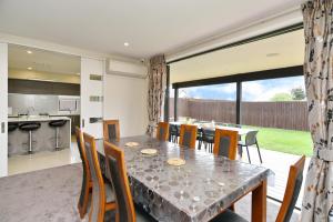 uma cozinha e sala de jantar com mesa e cadeiras em Spacious Family & Group Retreat - Wigram Residence em Christchurch