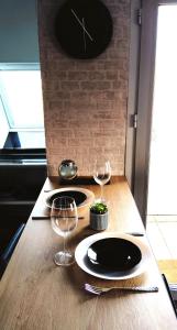 a table with two plates and wine glasses on it at Studio Alizée accès direct Promenade Marcel Proust in Cabourg
