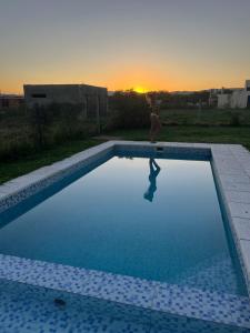 a person is standing next to a swimming pool at Mía Casa de Campo in Unquillo