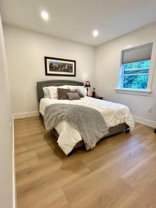 een slaapkamer met een groot bed en een raam bij Garagemahal on Glengyle in Milton Station +7 foto's