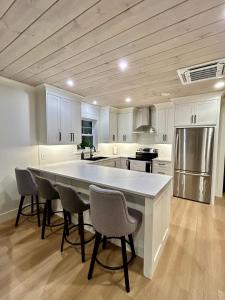 a kitchen with a large white table and chairs at Garagemahal on Glengyle in Milton Station