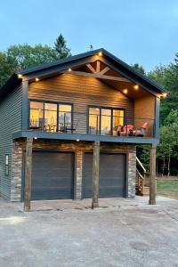 a house with two garage doors and a balcony at Garagemahal on Glengyle in Milton Station