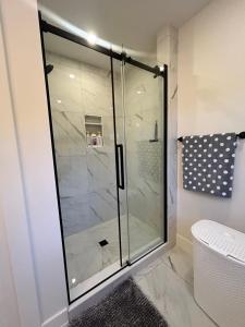 a shower with a glass door in a bathroom at Garagemahal on Glengyle in Milton Station +7 photos