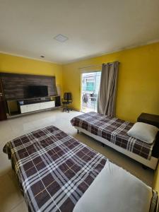 um quarto de hotel com duas camas e uma televisão em Grande metropóle de Belém em Ananindeua