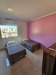 um quarto com duas camas e uma parede rosa em Grande metropóle de Belém em Ananindeua