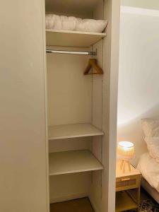 a closet with white shelves in a bedroom at Zen and chill F2 appartment and garden near Paris in Chelles