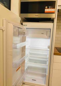 an empty refrigerator with its door open in a kitchen at Zen and chill F2 appartment and garden near Paris in Chelles +14 photos