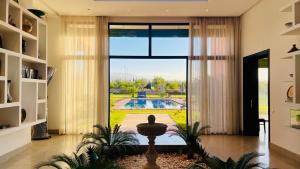 ein Wohnzimmer mit großer Glastür und einem Swimmingpool in der Unterkunft Villa Majestic Atlas 6ch in Loukid