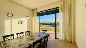 ein Esszimmer mit einem Tisch und einem großen Fenster in der Unterkunft Villa Majestic Atlas 6ch in Loukid