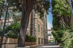 ein Backsteingebäude mit einem Baum neben einer Straße in der Unterkunft Appartement Original cœur de ville -AC- in Nizza
