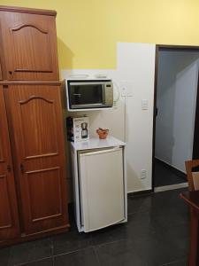a kitchen with a microwave and a small refrigerator at Kitnet estrela in Campos dos Goytacazes