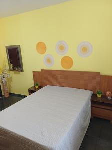 a bedroom with a bed with plates on the wall at Kitnet estrela in Campos dos Goytacazes