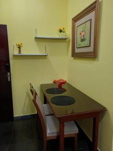 a dining room table with two chairs and a table at Kitnet estrela in Campos dos Goytacazes