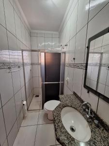 a white bathroom with a sink and a toilet at bairro Amambai - sobrado com 5 quartos e 5 banheiros in Campo Grande +57 photos