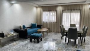 Una sala de estar con un sofá azul y una mesa. en Appartement neuf luxe OLM à Rabat, en Rabat